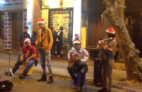 Một nhóm nghệ sĩ đường phố với trang phục đậm sắc màu Noel trình diễn nhạc không lời trên phố cổ. Ảnh: A.T