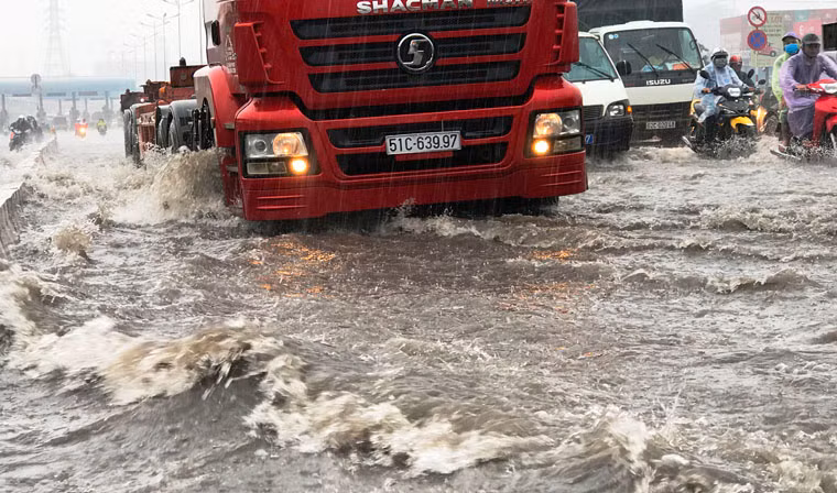 Xe cộ lưu thông qua khu vực ngập nước gặp nhiều khó khăn.
