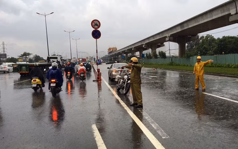 Lực lượng CSGT dầm suốt cơn mưa kéo dài suốt nhiều giờ để hướng dẫn người dân tránh đi vào khu vực ngập nước và điều tiết, phân luồng giao thông.