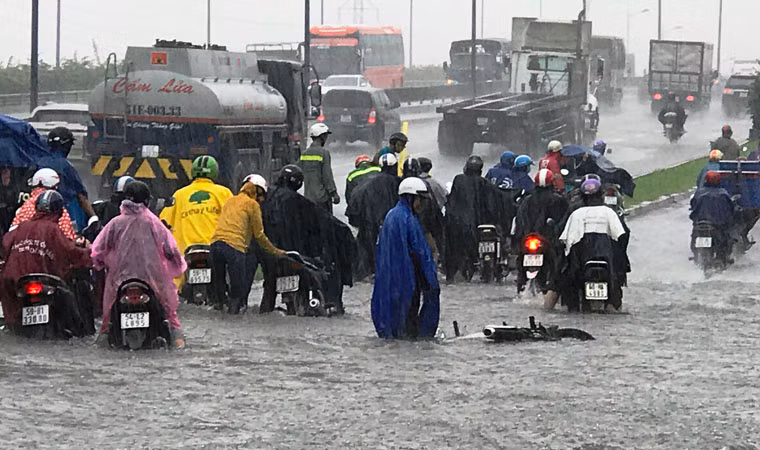 Không ít trường hợp bị té ngã do nước mưa ngập sâu trên đường dẫn lên cầu Rạch Chiếc.