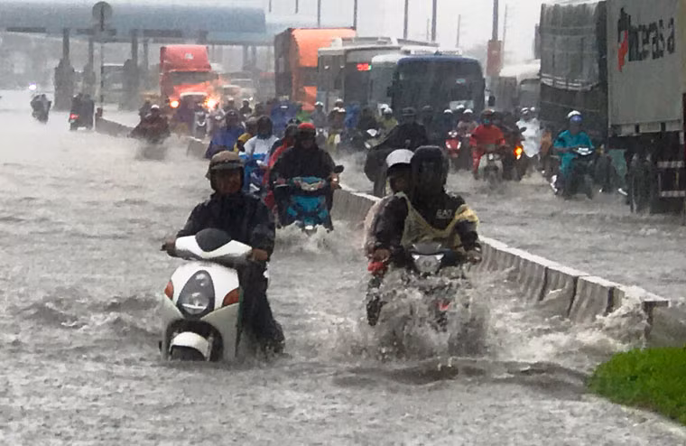 Mưa tuôn xối xả, trong khí phia dưới đường nước ngập sâu trong biển nước khiến người tham gia giao thông 1 phen khốn đốn.