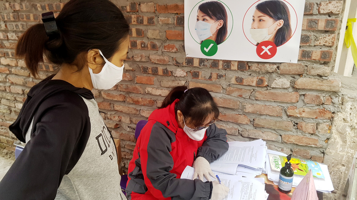 Chị Hương, một bệnh nhân của xóm được cử ra để hỗ trợ các cán bộ phường kiểm soát người ra vào trong xóm.