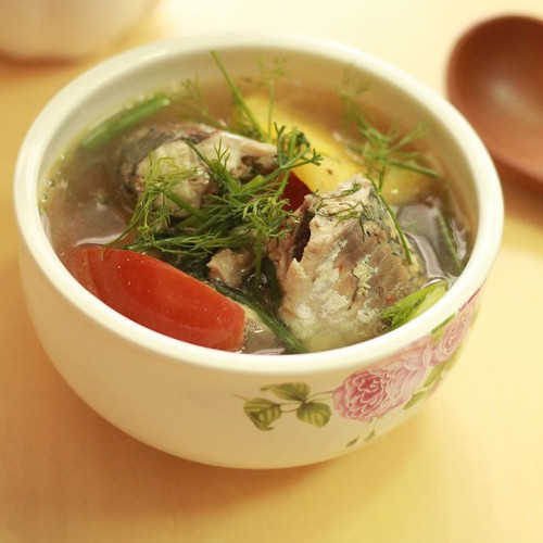 Cho dứa vào để tạo độ ngọt và vị thơm cho nước dùng, rồi trút cá vào. Thêm một chút nước me tạo độ chua. Cá chín vớt ra để riêng. Thêm dọc mùng, đậu bắp vào nấu chừng 3 phút cho mềm rồi cho giá đỗ vào. Canh sôi, cho cá lại vào nồi, rắc hành ngổ thái nhỏ lên và tắt bếp. Canh này dễ ăn và hợp với mọi thời tiết. Ảnh: amthucdongtay