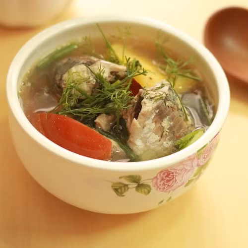 Cho dứa vào để tạo độ ngọt và vị thơm cho nước dùng, rồi trút cá vào. Thêm một chút nước me tạo độ chua. Cá chín vớt ra để riêng. Thêm dọc mùng, đậu bắp vào nấu chừng 3 phút cho mềm rồi cho giá đỗ vào. Canh sôi, cho cá lại vào nồi, rắc hành ngổ thái nhỏ lên và tắt bếp. Canh này dễ ăn và hợp với mọi thời tiết. Ảnh: amthucdongtay