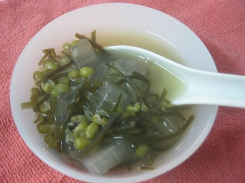 Đổ nước và đậu xanh vào nồi, đun sôi hớt bọt. Khi đậu xanh chín nhừ thì thêm đường vừa khẩu vị. Hòa tan bột sắn với nước, cho vào nồi đậu xanh, vừa đổ vừa ngoáy đều cho bột sắn tan đều. Thêm nha đam vào nồi, đợi sôi lại thì tắt bếp. Múc chè nha đam đậu xanh ra bát, để nguội, cho vào ngăn mát tủ lạnh hoặc ăn kèm đá. Ảnh: nau