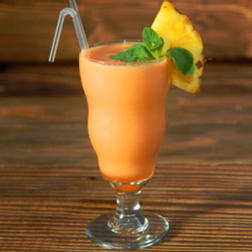 Dứa gọt vỏ, bỏ mắt, rửa sạch, cắt thành từng miếng vừa. Cà rốt nạo vỏ, cắt miếng nhỏ. Cho dứa, cà rốt cùng sữa đặc, đường kính và đá bào vào máy xay sinh tố xay cho thật nhuyễn mịn để tránh lợn cợn khi uống, rót ra cốc thưởng thức. Ảnh: khampha