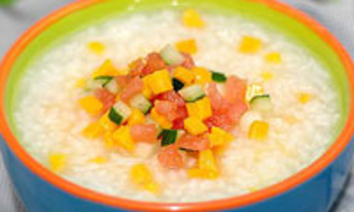 Cháo nguội thì cho các loại hoa quả xắt hạt lựu vào. Thêm ít đường phèn tạo độ ngọt và đảo đều. Ảnh: gox