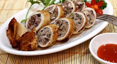 Nêm gia vị, hạt nêm, hạt tiêu, xì dầu, ướp ngấm rồi nhồi vào mực ống. Ghim đầu mực để thịt không bị rời ra. Bọc giấy bảo quản rồi cho vào lò vi sóng quay. Mực chín để nguội và cắt thành khoanh bày ra đĩa. Ảnh: ktdt