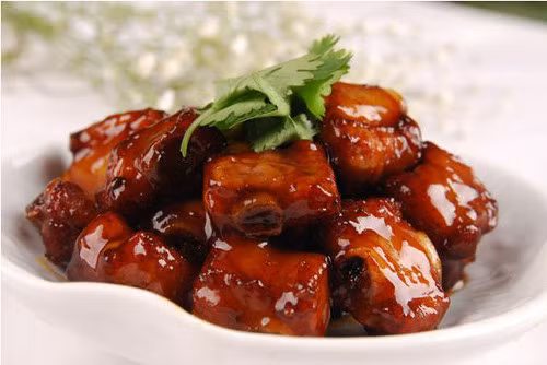 Tiếp theo cho sườn vào đảo sém cạnh. Pha nước sốt cho món ăn gồm nước lạnh, dấm ăn, nước ép táo, đường, dầu ăn. Đảo qua đảo lại cho sườn ngấm đều nước sốt, sau đó trút ra đĩa. Ảnh: agiadinh