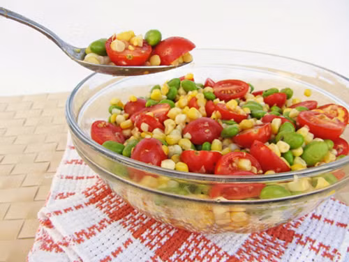 Sau đó cho ngô vào tô trộn đều cùng với đâu Hà Lan và hành tây. Xay nhuyễn cà chua. Trộn đều với hạt nêm, tiêu, dầu ôliu, nước cốt chanh để tạo thành nước sốt. Rưới nước sốt lên salad và trang trí rau mùi để món ăn thêm đẹp mắt. Ảnh: webphunu