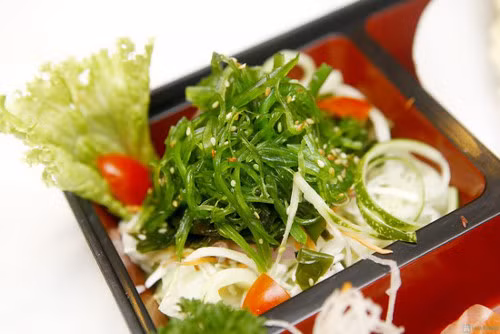  Salad rong biển là món ăn đơn giản, mát và có tác dụng giúp giảm cân. Rong biển ngâm, rửa sạch rồi tước thành sợi nhỏ. Vừng trắng rang vàng. Dưa chuột rửa sạch, bỏ ruột, cắt lát. Trộn dưa chuột, rong biển với giấm, đường, muối sao cho vừa. Để khoảng 5-10 phút cho ngấm rồi cho salad ra đĩa. Xếp xà lách xung quanh và rắc vừng lên trên. Ảnh: bloggiamcan