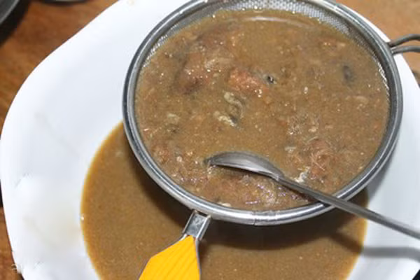 Đầu tiên làm chẻo cá linh. Bạn cho nước vào nồi đun sôi rồi thả mắm cá linh vào nồi đun đến khi mắm cá mềm dẻo. Khi đã thấy mắm hòa vào nước thì dùng rây để lọc lấy phần nước. Nếu như không tìm được mắm cá linh, bạn có thể thay thế bằng mắm cá sặc ở bước này. (Ảnh: Amthuc365).