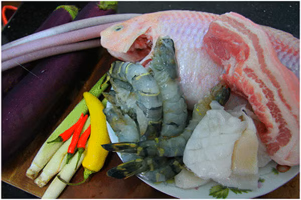 Nguyên liệu sẽ phải chuẩn bị “chuyên nghiệp” một chút gồm nhiều hương vị: mắm cá linh hoặc mắm cá sặc, thịt heo ba chỉ, mực ống, cá lóc phi lê, tôm tươi, sả, cà tím, ớt sừng, khổ qua, hành tím, tỏi, hành hoa. Và tất nhiên là không thể thiếu bún. (Ảnh: Webnauan).