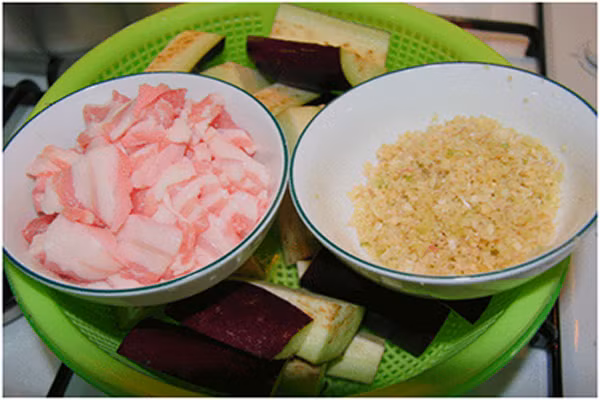 Đun nóng một ít dầu ăn rồi phi thơm sả. Khi sả đã ngả màu vàng sẫm cho thịt vào đảo đều tay, đến khi thịt chín sơ bên ngoài tiếp tục đổ cà đã xắt vào xào qua. Su đó cho nước cốt mắm đã lọc trước đó vào đun sôi. (Ảnh: Webnauan).