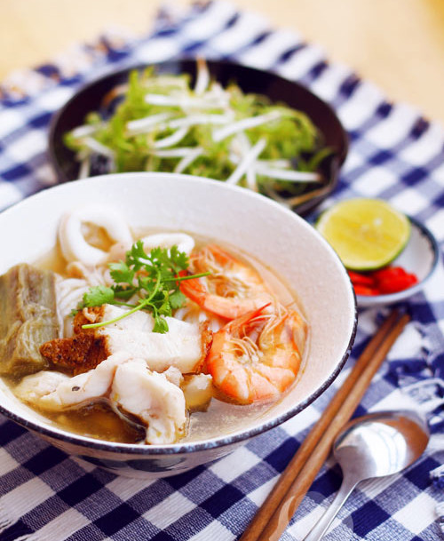 Hoàn thành xong nồi nước dùng. Công đoạn cuối cùng là cho bún vào tô, xếp tôm, cá, mực lên trên rồi thêm một lớp rau thơm và múc nước nấu nóng hổi vừa xong vào bát. Vậy là bạn đã có một tô bún mắm dậy mùi rất đặm đà. (Ảnh:Lamsao).