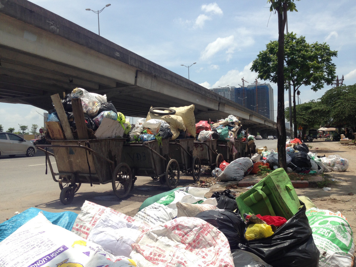 Nhiều xe rác được tập kết trên đường Phạm Hùng cho thấy, lượng rác trên xe quá tải nằm ngổn ngạn giữa lòng đường, vỉa hè gây ảnh hưởng đến người đi lại. Ông Trần Văn Quang (Trú tại làng Kim Giang, phường Đại Kim) chủ cửa hàng kinh doanh nước trên đường Phạm Hùng nói: "Mấy ngày gần đây xe rác xếp dài từ sáng đến chiều gây mùi hôi thối, mấy hôm trời mưa nước rỉ từ xe ra ngoài đường mùi hôi thối bốc ra càng nhiều, gây mất vệ sinh tôi còn phải nghỉ bán hàng".