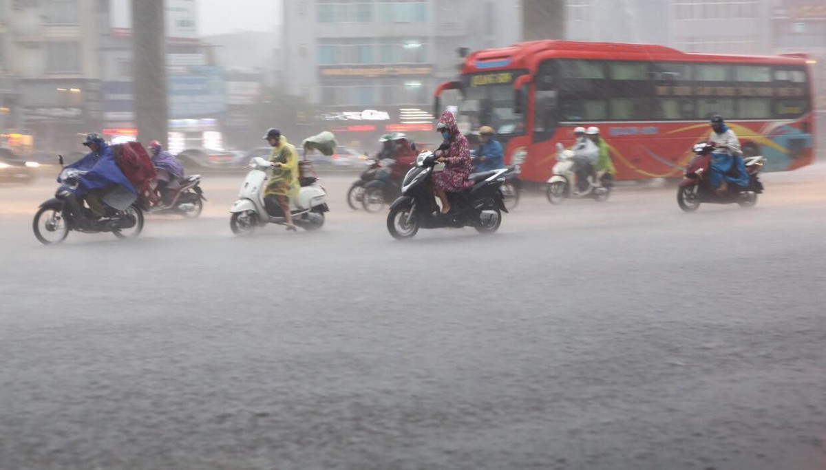 Mưa lớn khiến nhiều người di chuyển trên đường gặp khó khăn.