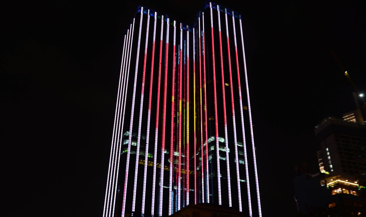 Nhiều nhà cao tầng ở trung tâm Sài Gòn rực rỡ ánh đèn với hình ảnh cờ đỏ sao vàng chào mừng ngày chiến thắng 30/4 lịch sử.