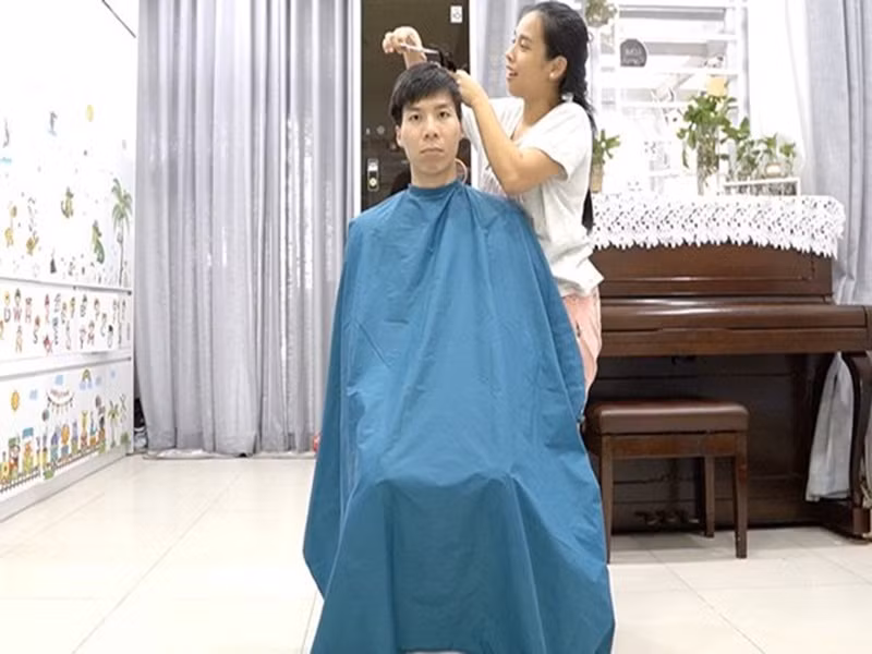 Ca sĩ Ngọc Mai cắt tóc cho ông xã Quốc Nghiệp khi tiệm cắt tóc đóng cửa.