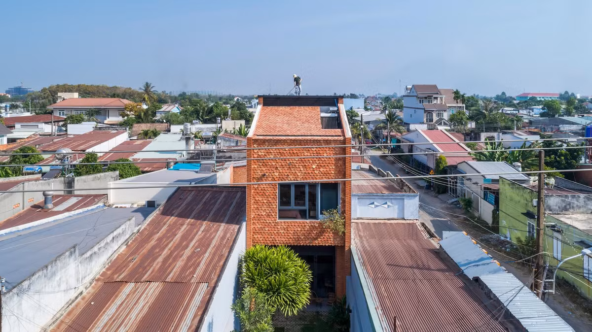 Ngôi nhà này sử dụng ngói vảy cá màu đỏ để lát toàn bộ mặt tiền và mái (trừ phần cửa sổ lớn tại tầng 2 và giếng trời ở tầng thượng). Thiết kế tuy đơn giản nhưng lại tạo ra sự độc đáo và mát mẻ cho ngôi nhà vì ngói được coi là vật liệu cách nhiệt vô cùng tốt từ xưa đến nay.