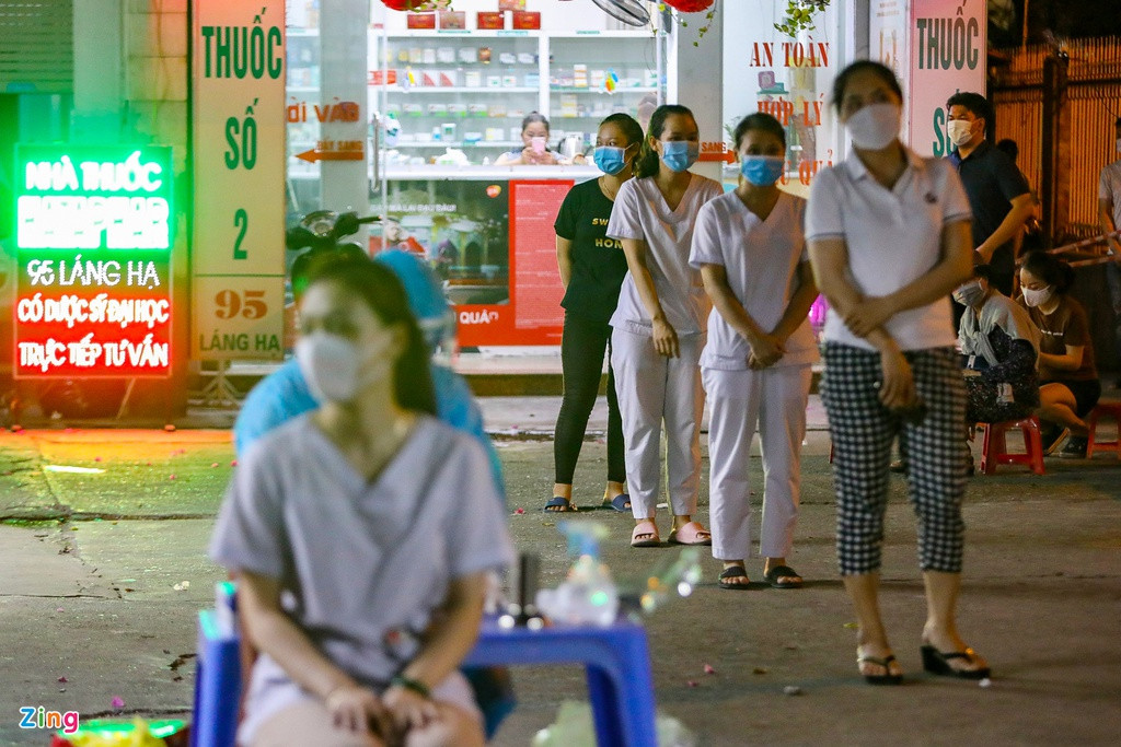 Những người thuộc diện phải xét nghiệm được hướng dẫn đứng giãn cách, xếp hàng theo thứ tự trong khi chờ lấy mẫu xét nghiệm.
