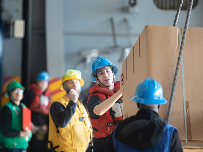 Khoang dưới của tàu sân bay Mỹ tấp nập trong những đợt chuyển hàng. Không chỉ nhiên liệu mà hàng hoá, lương thực thực phẩm, thư từ cũng đều được chuyển theo cách này. Nguồn ảnh: BI.