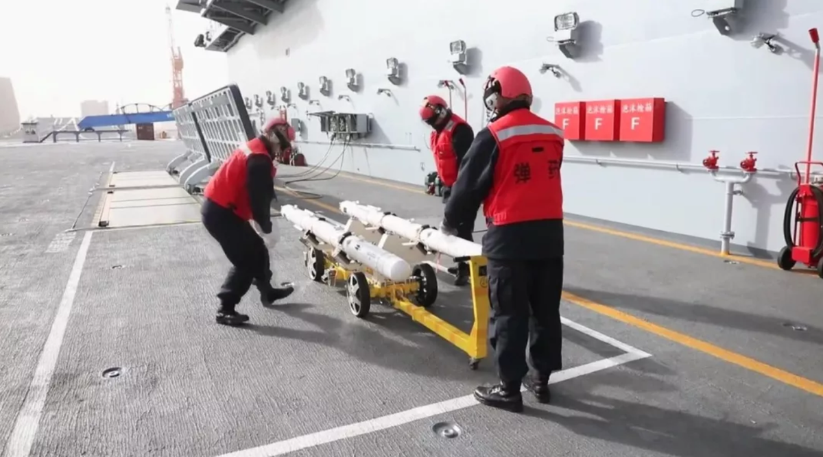 Nhiệm vụ nạp vũ khí cho các chiến đấu cơ trên tàu sân bay Sơn Đông cũng được giao cho các nhân viên với đồng phục đỏ - giống hệt trên tàu sân bay Mỹ. Nguồn ảnh: Sina.