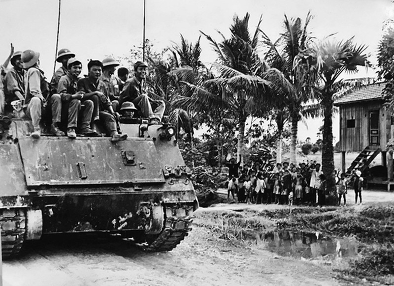 Lính Việt Nam trên xe thiết giáp M113 - một chiến lợi phẩm được ta thu giữ từ kháng chiến chống Mỹ - băng qua một phum (làng) của Campuchia. Nguồn ảnh: TL.