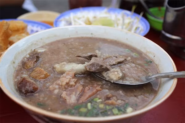 Muốn có một bữa sáng thanh cảnh, ấm bụng lại rẻ, bạn có thể chọn mua những bát cháo thơm sánh, nóng hổi. Một bát cháo thịt bằm hay cháo huyết bên trong các khu chợ hay các xe đẩy trên đường cũng có giá khá mềm. 