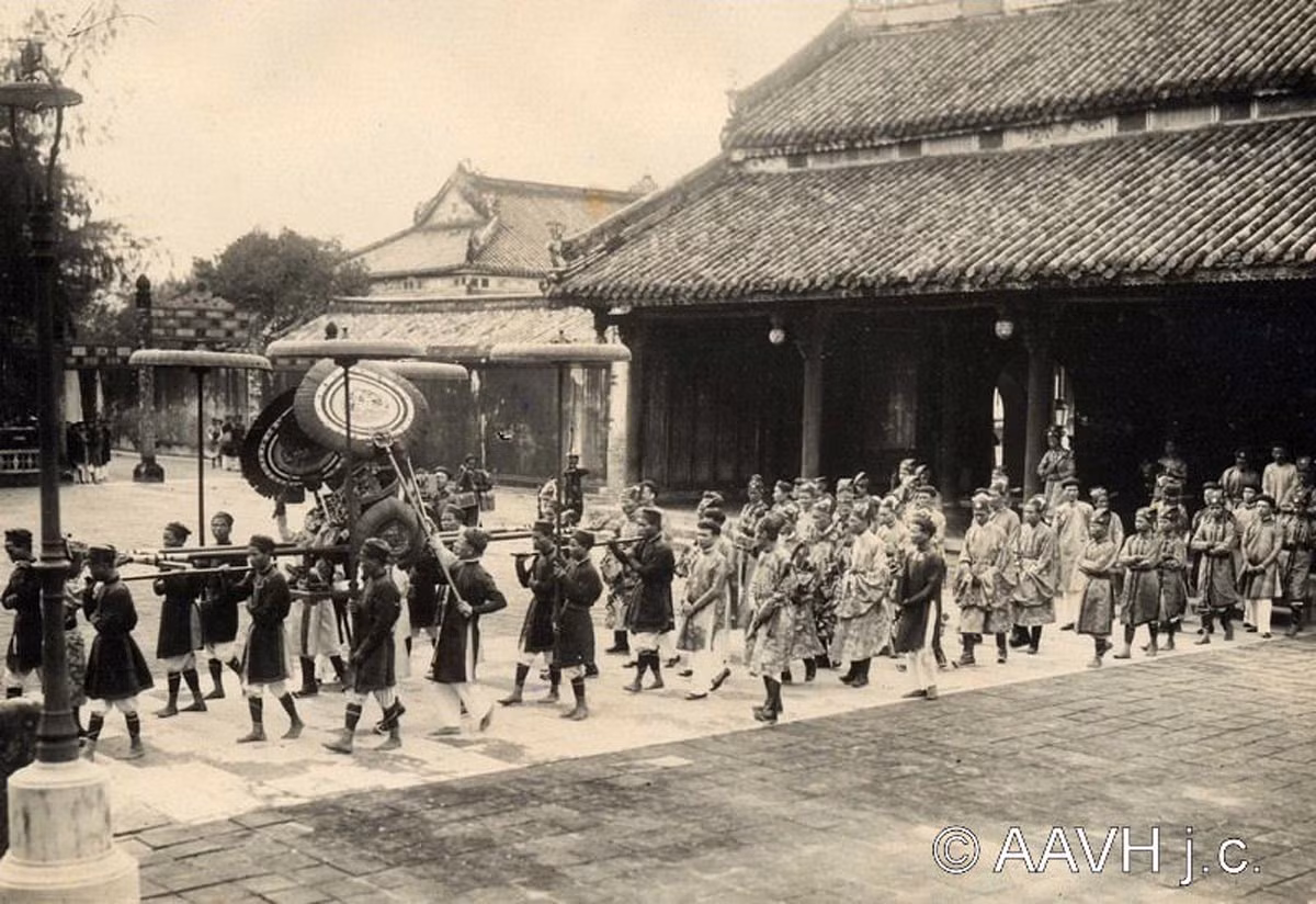 Vua Bảo Đại được rước từ điện Cần Chánh đến điện Thái Hòa, nơi đặt ngai vàng. Các quan chức trong triều phục đi phía sau. Ảnh: AAVH.