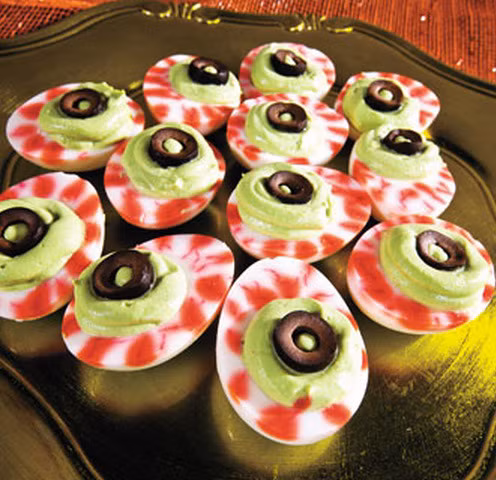 Cắt đôi quả trứng đã bóc vỏ và trang trí thêm 1 quả oliu đen, một tí tương ớt xung quanh cho món ăn thêm sống động. Thế là bạn đã hoàn thành quả trứng quỷ " mắt khổng lồ " rất đơn giản phải không?