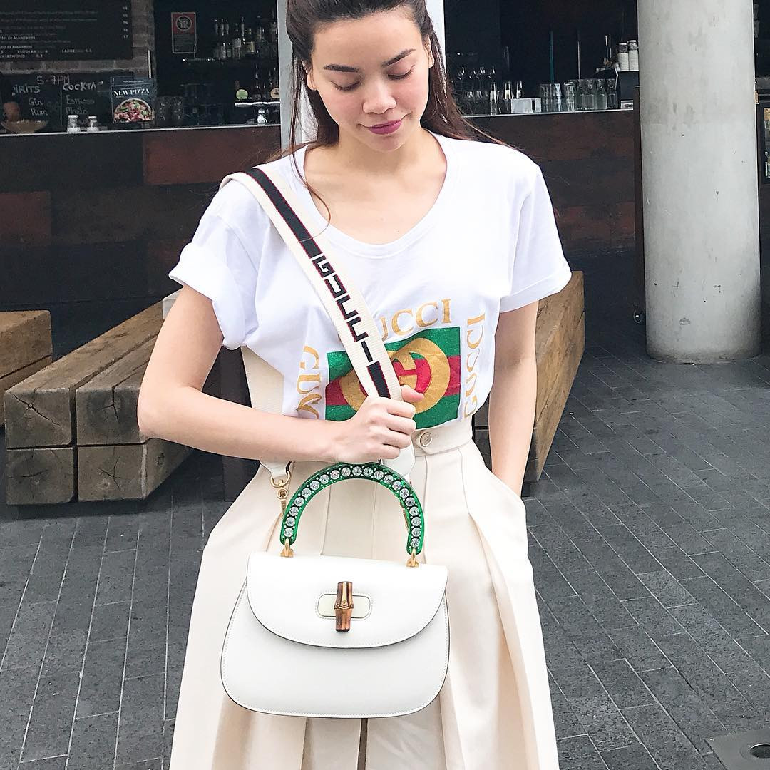 Hồ Ngọc Hà kết hợp áo phông của Gucci cùng trang phục cạp cao với những đường xếp ly tạo độ phồng và đeo thêm túi xách. Màu trắng và màu kem tạo hiệu ứng đồng bộ khiến trang phục không hề mắc lỗi về màu sắc.
