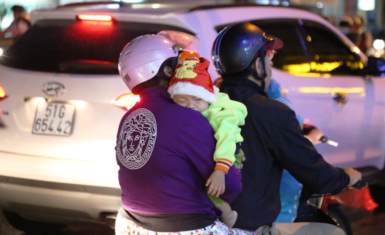 Có bé được cha mẹ chở về nên đã ngủ gật luôn trên xe máy.