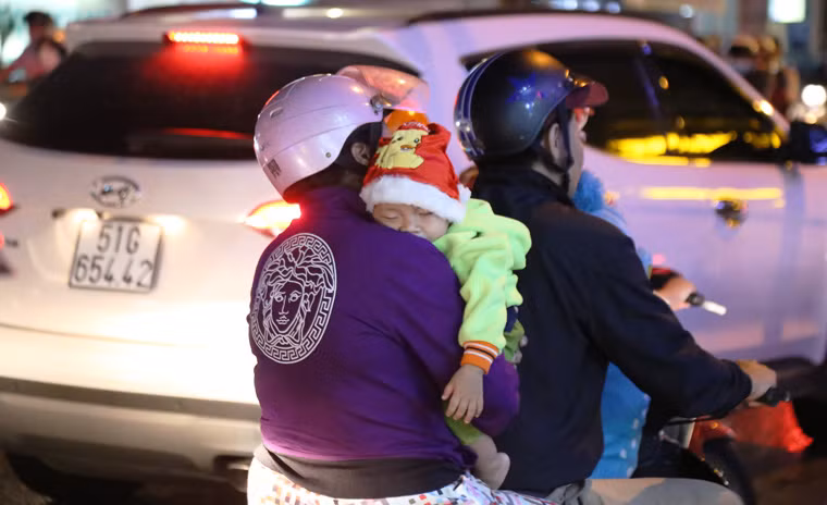 Có bé được cha mẹ chở về nên đã ngủ gật luôn trên xe máy.