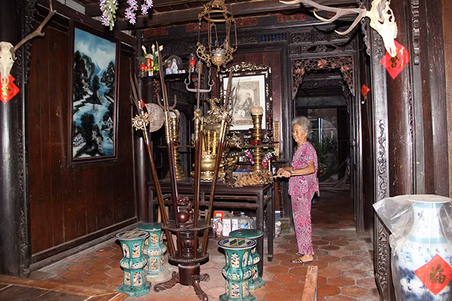 Gian chính dùng để tiếp khách còn lưu giữ 2 bảng thiếp vàng, ghi 2 hàng câu đối bằng chữ Hán; chính giữa là bàn thờ. Ảnh: Thethaovanhoa.