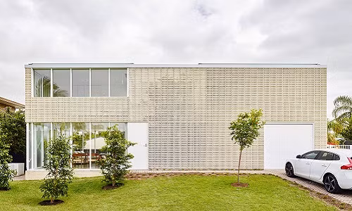 Sân cỏ phía trước nhà trở thành không gian vui chơi lý tưởng của lũ trẻ. Nguồn ảnh: Archdaily.