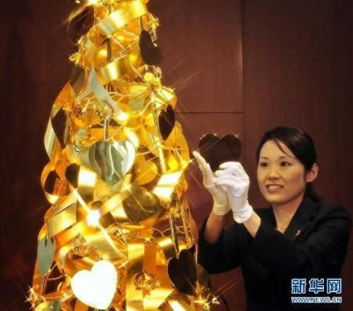 Cây thông cao 2,4m được trang trí hơn 100 dải duy băng, bông hoa và các trái tim bằng vàng. Ảnh: News.