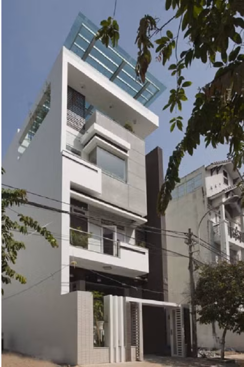 Căn nhà ống khoác lên mình chiếc áo trắng xám đơn giản, không gian thoáng mát, nhiều cây xanh. Ảnh: Khonggiannhadep.