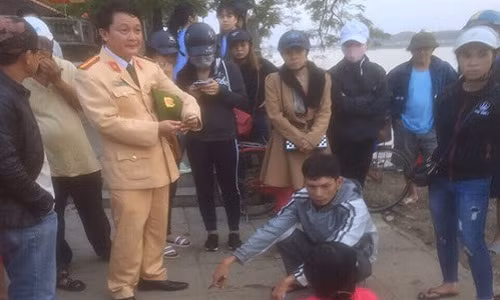 Chị D (áo đỏ) sau khi được CSGT cứu sống và đưa lên bờ.