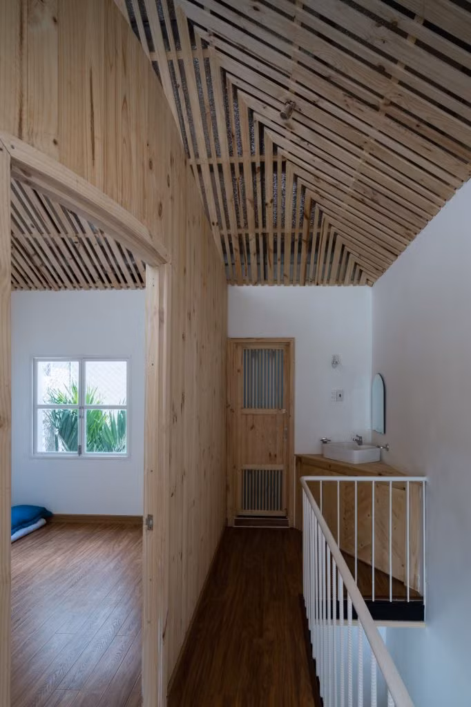 Phòng ngủ nhỏ, giản dị có cửa sổ hướng ra không gian xanh.