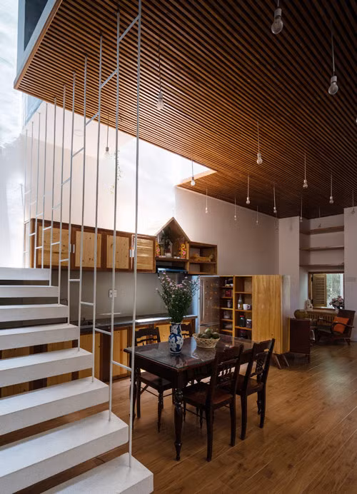 Bàn ăn mộc mạc đặt giữa ánh sáng và bóng tối, tạo không khí hoài niệm.