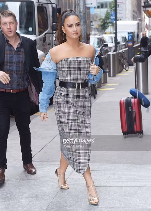 Demi Lovato nổi bật trên đường phố New York với đầm kẻ kết hợp thắt lưng to bản và áo khoác denim khỏe khoắn.
