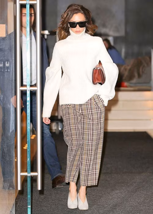 Vic chọn áo len cao cổ trẻ trung khi kết hợp cùng mốt quần rộng kẻ ô năng động.