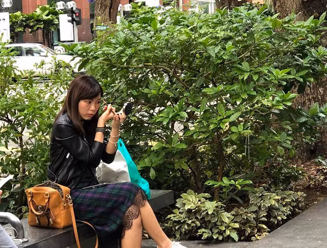 Một bạn gái tranh thủ trang điểm trong lúc chờ mua iPhone X. Ảnh: Facebook Xì Trum 8.