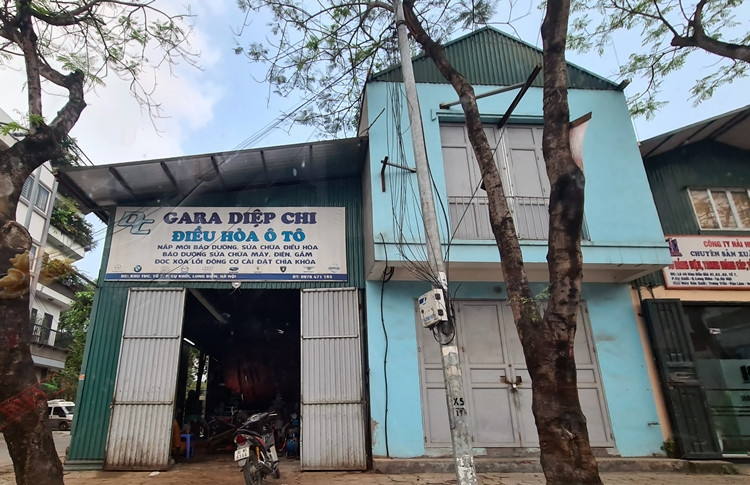 Công trình quây tôn xanh (bên trái) nằm sát ngôi nhà xây dựng hai tầng, được sử dụng làm gara sửa chữa điều hòa ô tô.