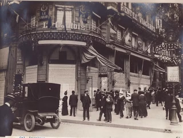 Rất đông người dân Paris đi lại phía trước một cửa hàng cafe.