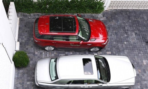 Chiếc Range Rover màu đỏ cạnh chiếc Rolls Royce Plantom.