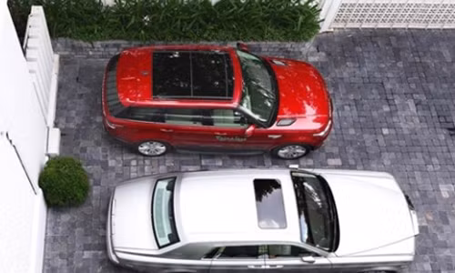 Chiếc Range Rover màu đỏ cạnh chiếc Rolls Royce Plantom.