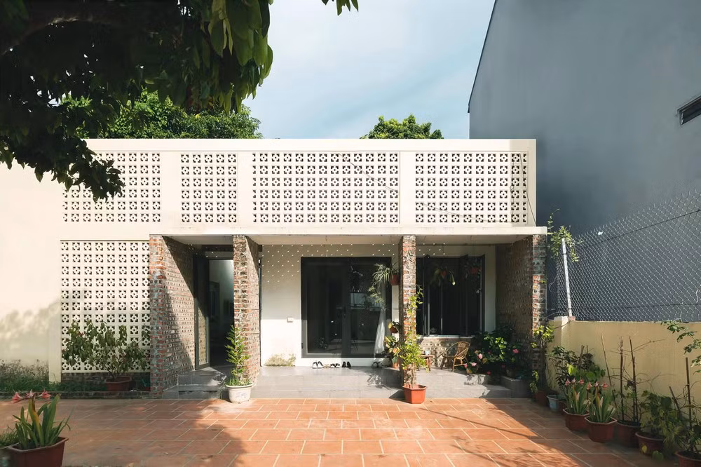 Ngôi nhà cấp 4 hoàn toàn “lột xác” sau cải tạo, mặt tiền nổi bật với sự kết hợp của mảng tường gạch bông gió màu trắng và gạch trần thô mộc. Mặt tiền gạch bông gió vừa có tác dụng cản nắng nóng, đồng thời điều hoà không khí trong - ngoài hiệu quả.