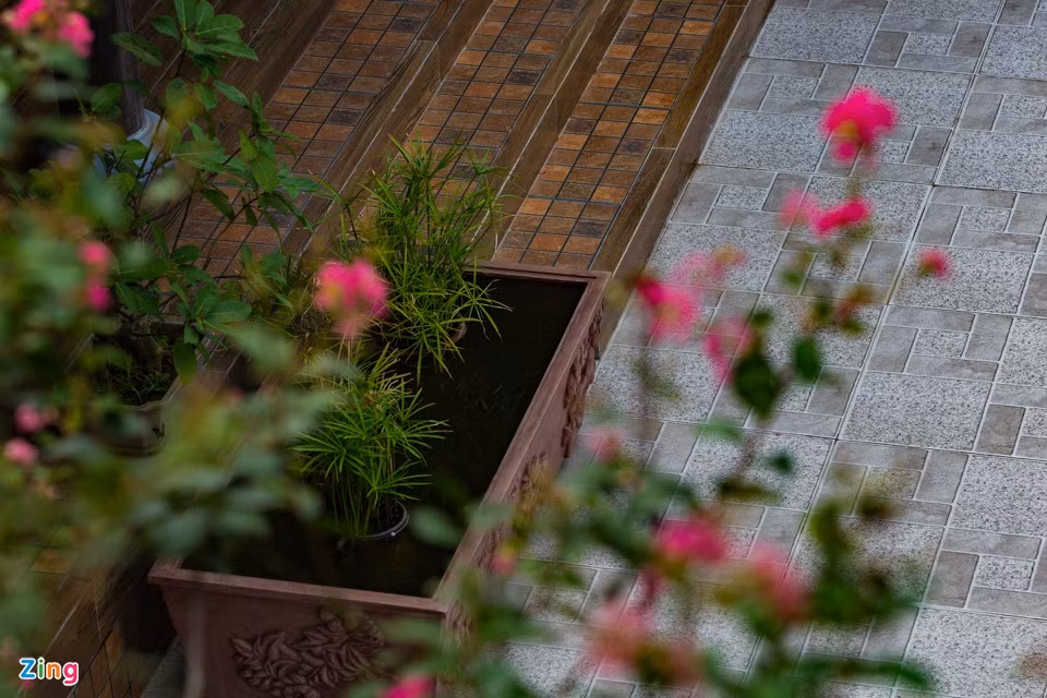 Điểm nổi bật khác trong cấu trúc cách tân của công trình này là nền gạch sân không dùng gạch đỏ mà lát gạch trắng. Theo gia chủ, căn nhà ở trên cao dễ bắt nắng nên lát gạch trắng sẽ giảm đi, điều đó làm nền nhà mát hơn. Đồng thời, các vật trang trí sẽ nổi bật, không bị lẫn màu. Bậc thềm bước vào gian nhà cổ cũng được thay đổi, nhìn mới mẻ, hiện đại. "Mình duy trì và phát triển chứ không chỉ dựng lại như lối cổ xưa, cảnh quan phù hợp lối sống hiện tại, cách tân hơn", chị Liên giải thích thêm.